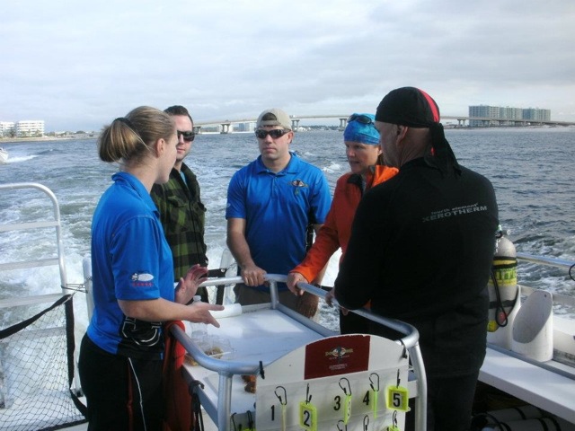 The dive crew is briefed by Jill Heinerth (in orange) prior to an underwater shoot for We Are Water.