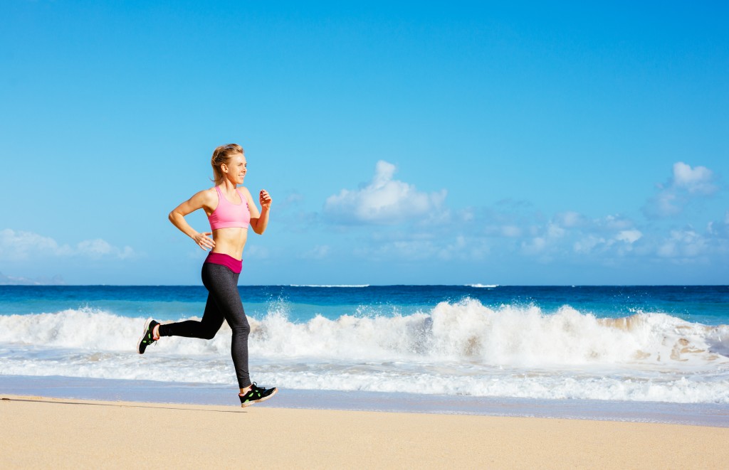 Athletic Fitness Woman Running on the Beach