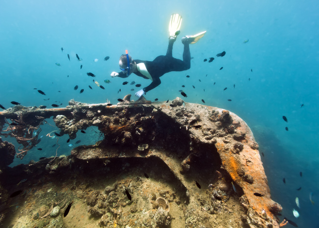 Diver exploring shipwreck underwater. Gunboat at Lusong Island