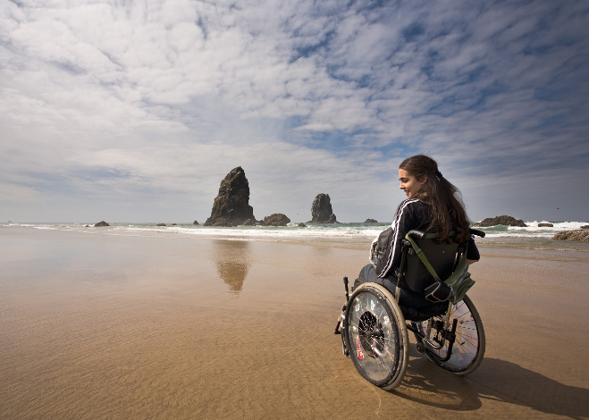 woman in a wheel chair visiting a beach
