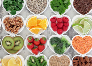 Super food selection for health diet in porcelain bowls over distressed wooden background.
