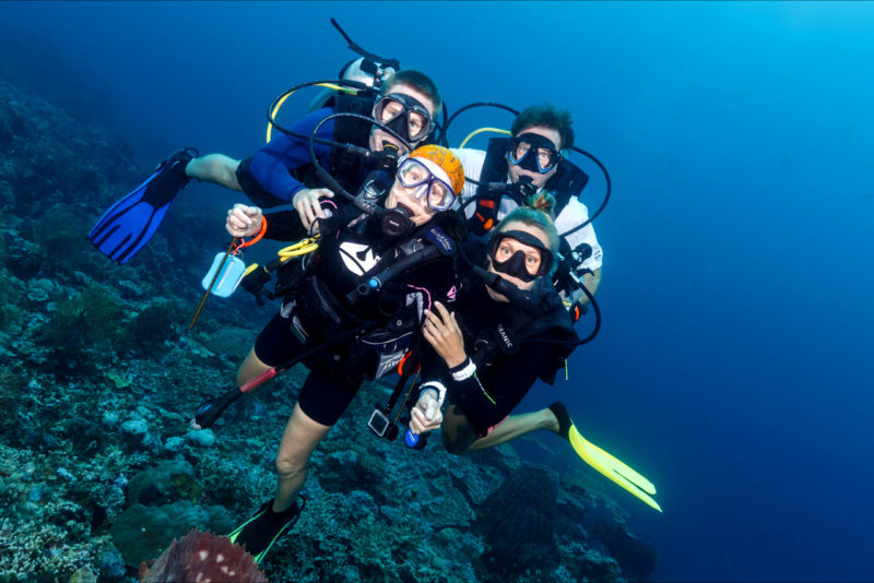 The Bennett family poses for the camera underwater at Wakatobi (Courtesy Wakatobi Resort)